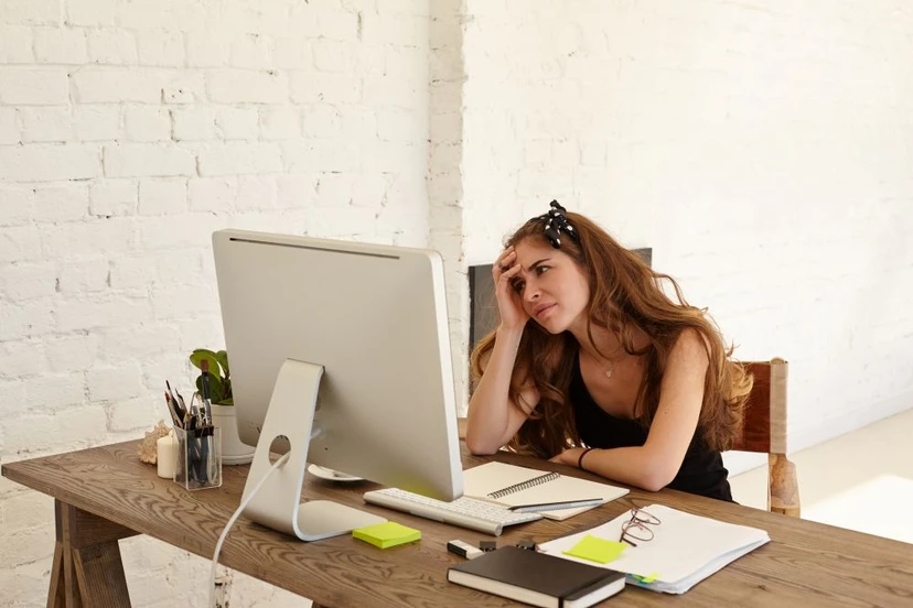 Therapist overwhelmed at her desk, therapy notes and documentation